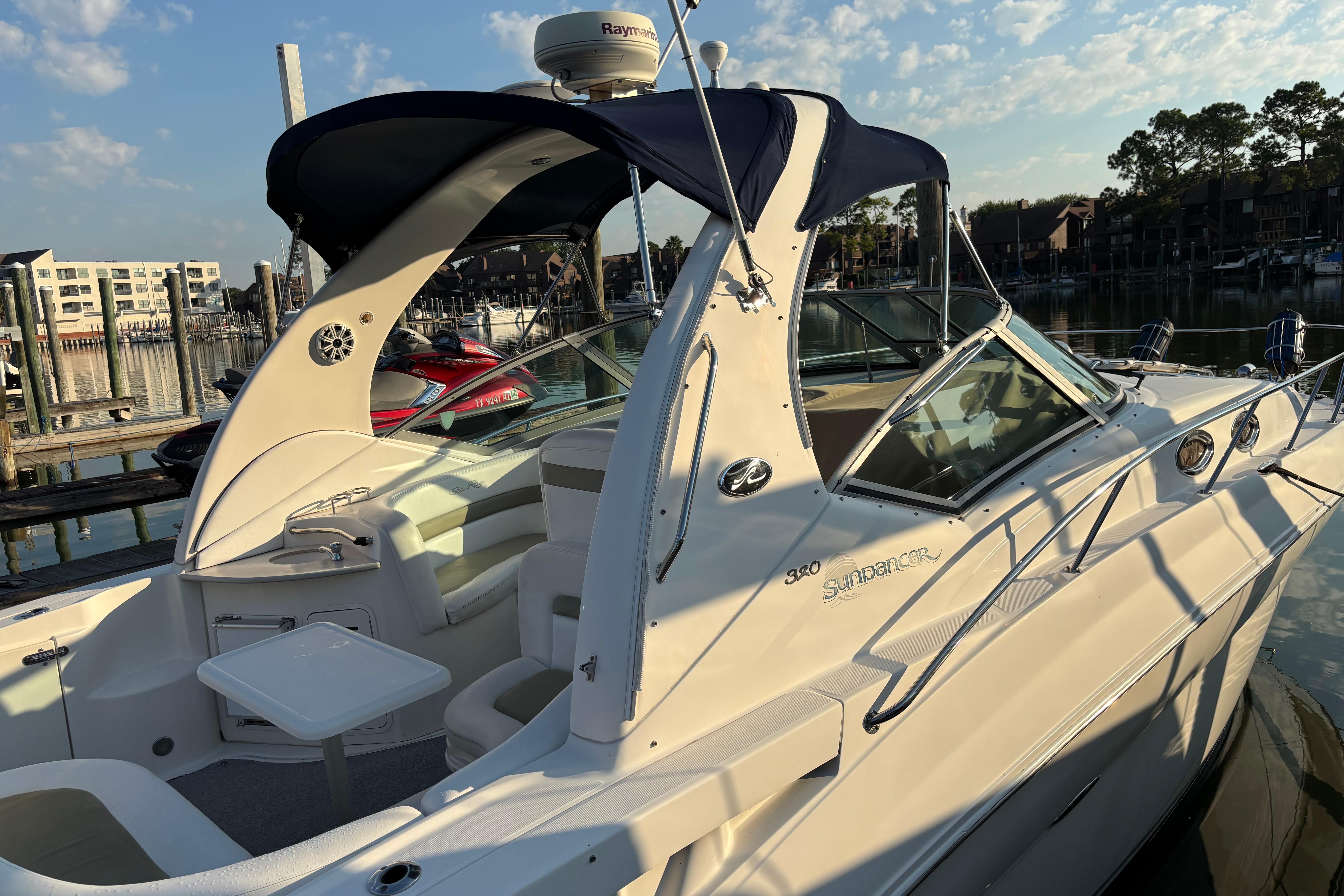 Sea Ray Sundancer 320 2006 Sea Ray Sundancer 320 docked, featuring sleek design and spacious deck under a clear sky.