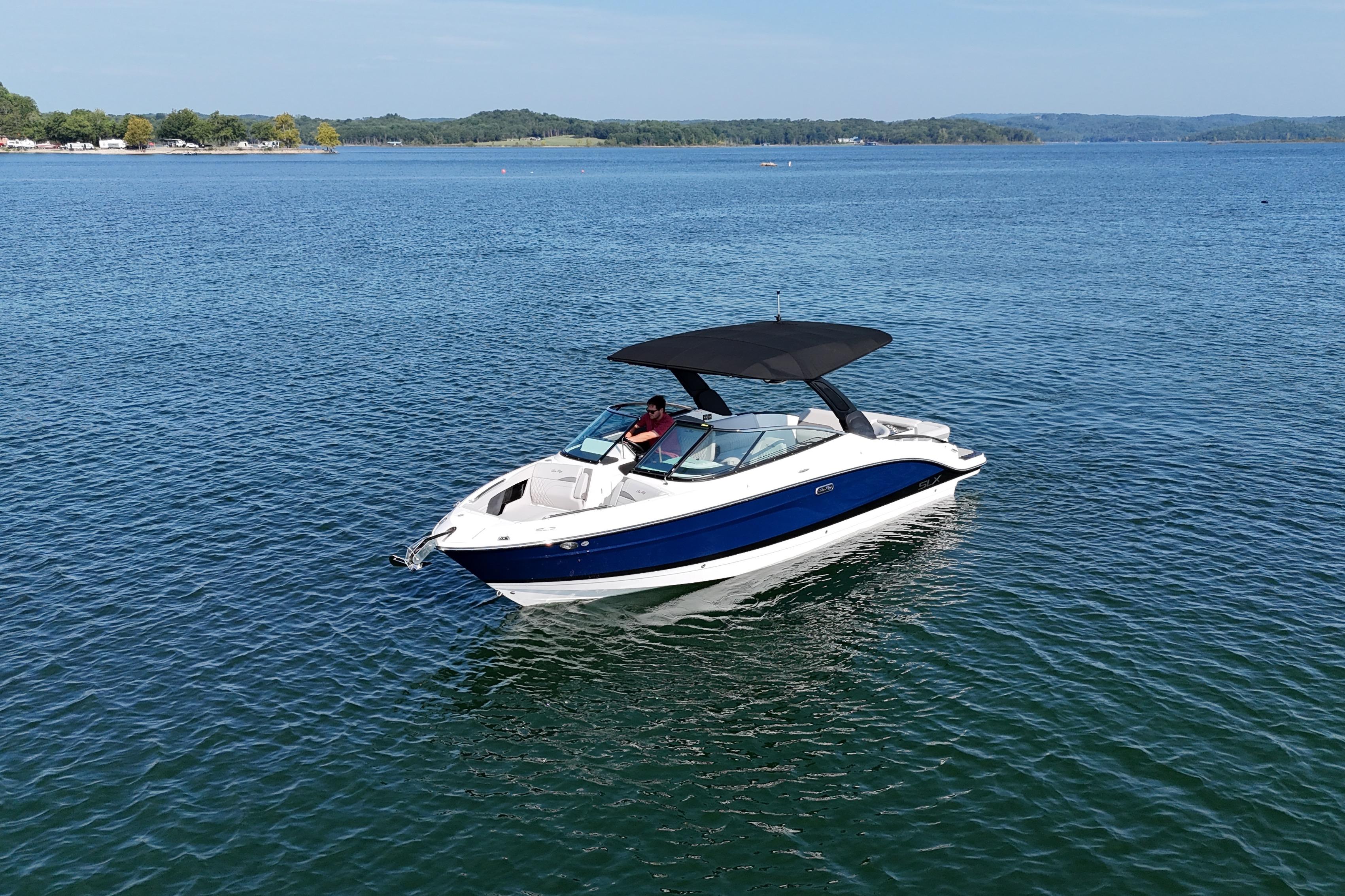 Sea Ray SLX 280 2024 Sea Ray SLX 280 boat cruising on a serene lake under clear skies.