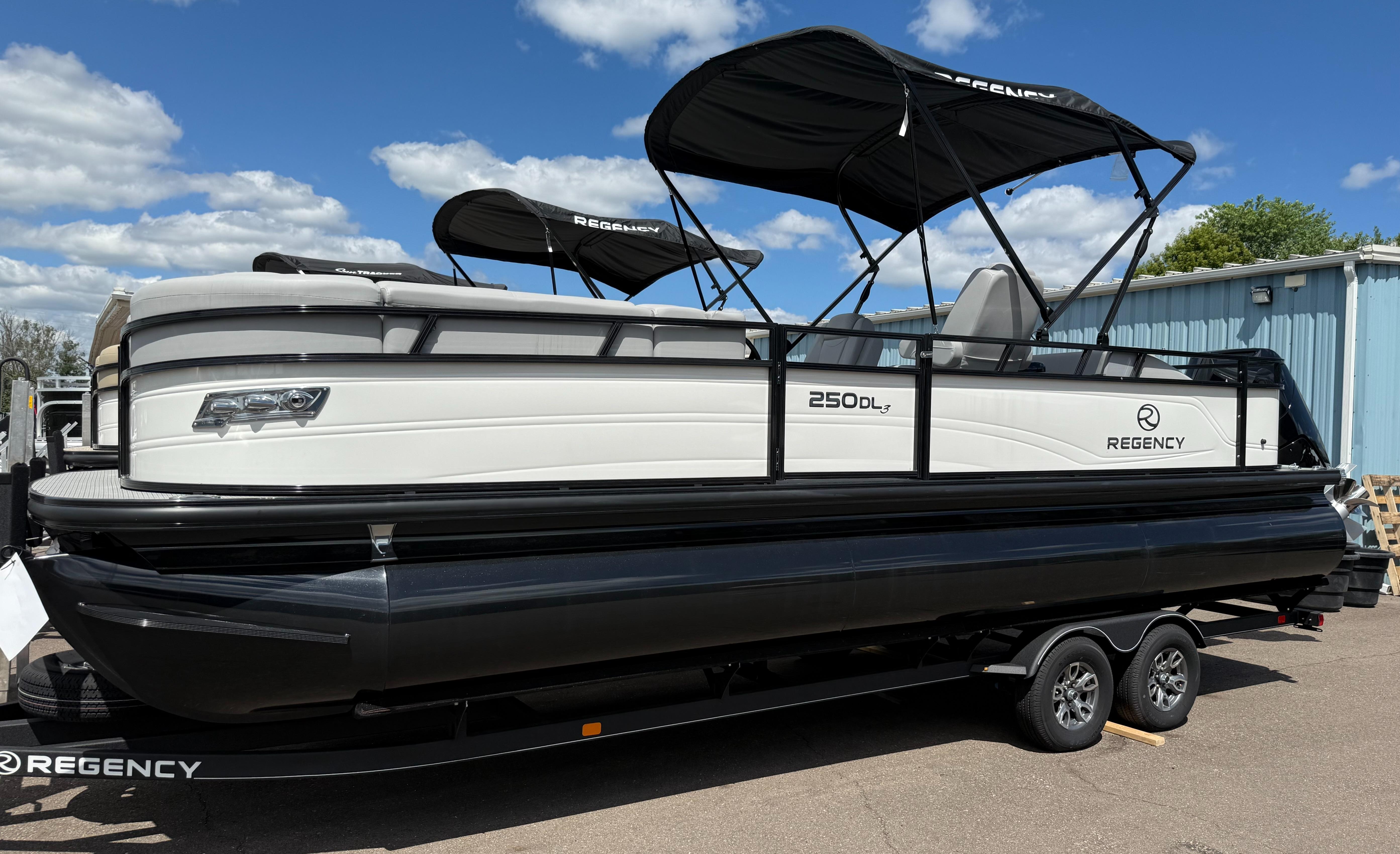 Regency 250 DL3 2024 Regency 250 DL3 pontoon boat with black canopy on a trailer.