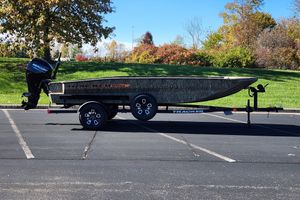 Tracker Grizzly 1756 T Marsh 2026 Tracker Grizzly 1756 T Marsh boat on trailer in parking lot.