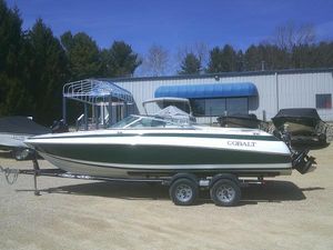 Cobalt 220 1998 Cobalt 220 boat on trailer, parked outdoors near a building.