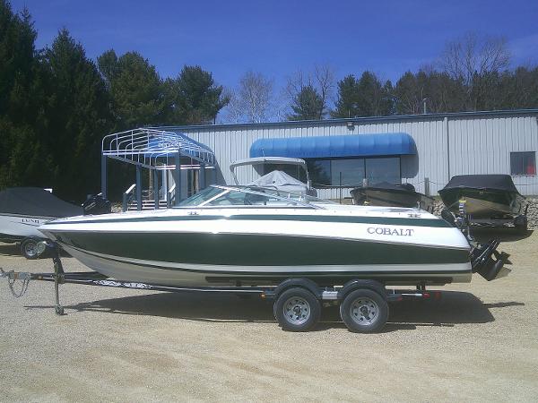 Cobalt 220 1998 Cobalt 220 boat on trailer, parked outdoors near a building.