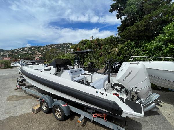 Iron 827 2025 Iron 827 boat on trailer with Mercury engine, parked outdoors.