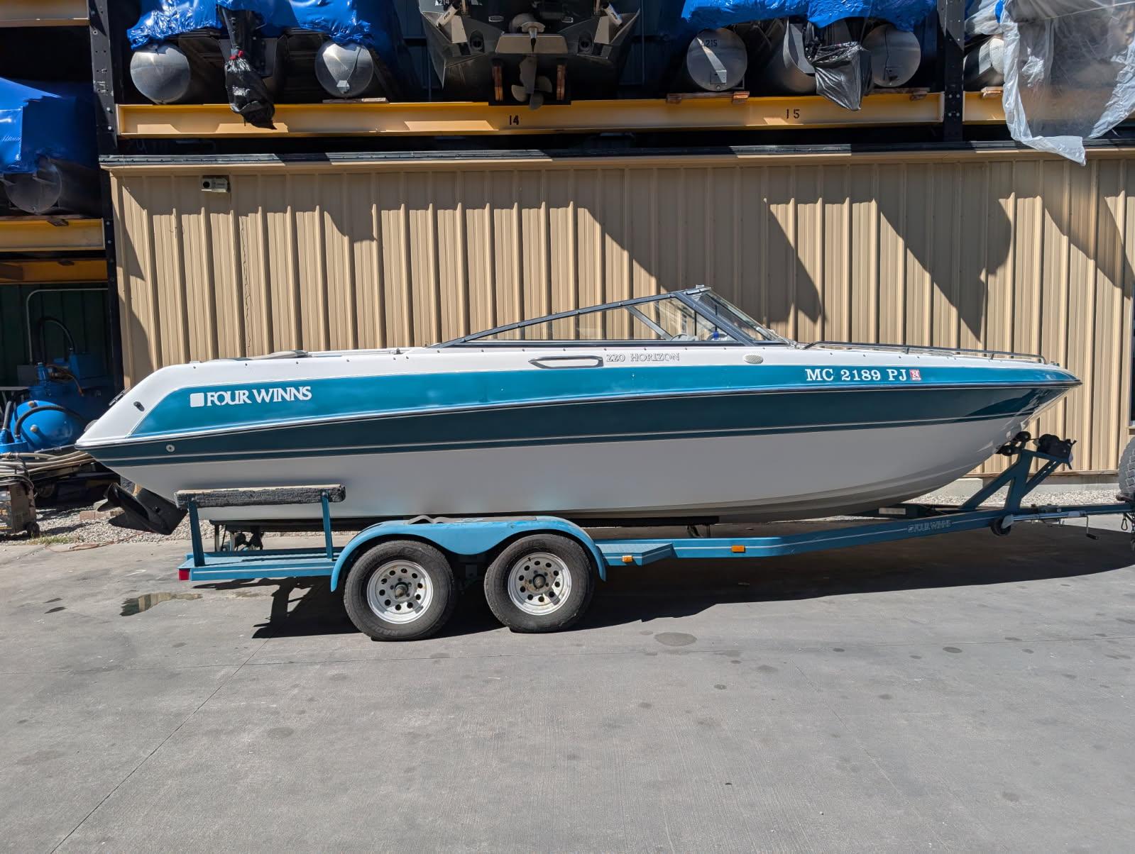 Four Winns 220 Horizon 1992 Four Winns 220 Horizon boat on trailer, parked outdoors.