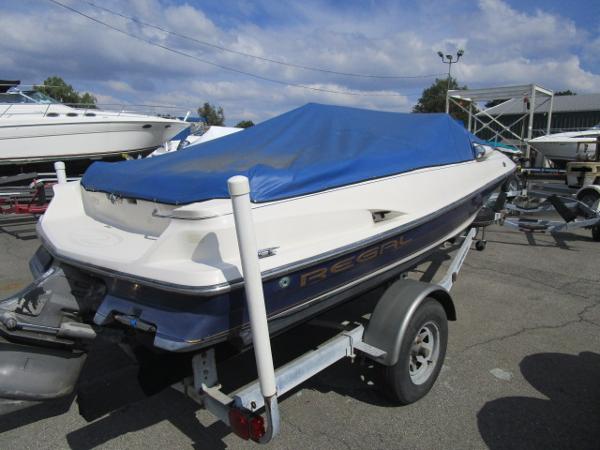 Regal 1700LSR 1999 Regal 1700LSR boat with blue cover on trailer, parked outdoors.