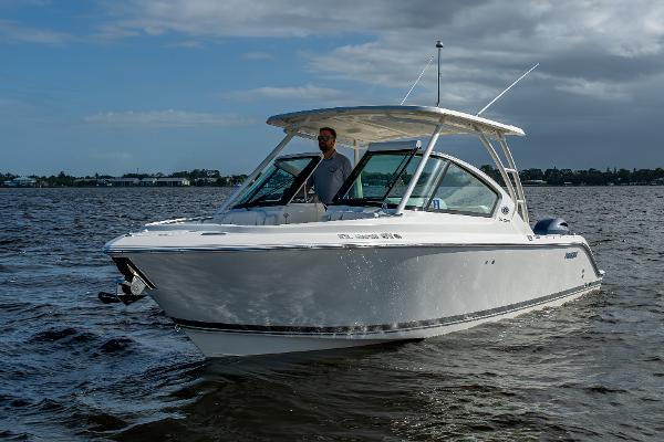Pursuit DC 266 Dual Console 2021 Pursuit DC 266 Dual Console boat cruising on a calm lake under a cloudy sky.