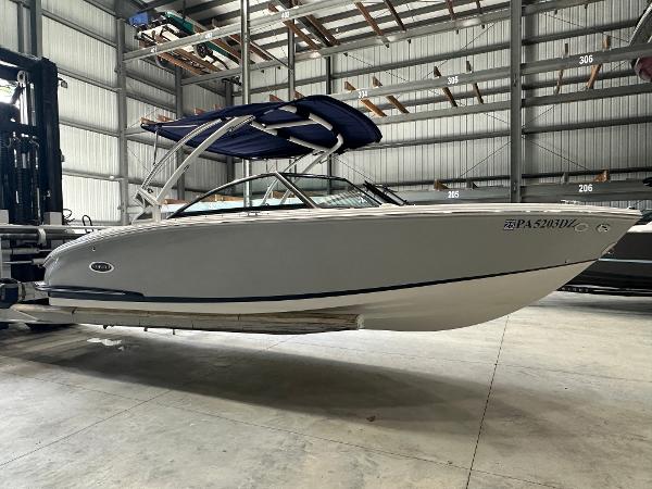 Cobalt CS23 2021 Cobalt CS23 boat in storage facility, side view with blue canopy.