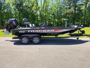 Tracker Savage 215 2025 Tracker Savage 215 boat on trailer, parked on road with forest background.