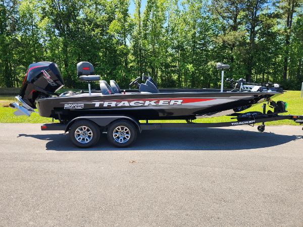 Tracker Savage 215 2025 Tracker Savage 215 boat on trailer, parked on road with forest background.