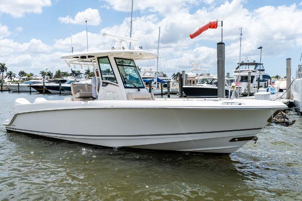 Boston Whaler 280 Outrage 2020 Boston Whaler 280 Outrage boat docked in a marina under a partly cloudy sky.