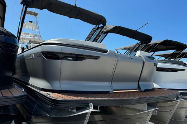 Manitou Explore Navigator 2024 Manitou Explore Navigator boat with sleek design and modern features, docked under clear blue sky.