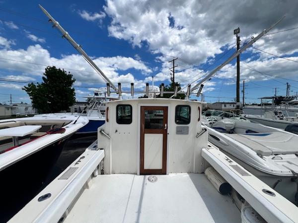 Parker 2520 Modified Vee Sport Cabin 1989 Parker 2520 Modified Vee Sport Cabin boat docked under a partly cloudy sky.
