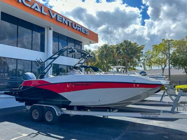 Starcraft SVX 231 OB DH 2024 Starcraft SVX 231 OB DH boat on trailer outside a dealership under a cloudy sky.