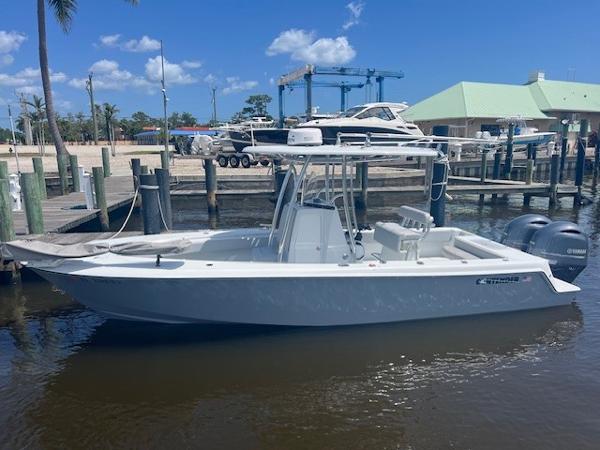 Contender 25 Tournament 2023 Contender 25 Tournament boat docked at marina under clear blue sky.