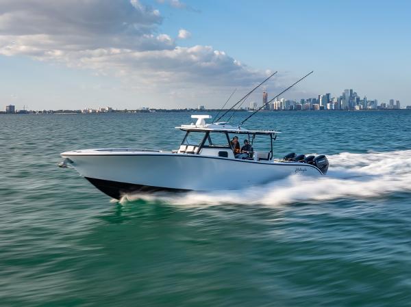 Yellowfin 42 2024 Yellowfin 42 boat cruising on open water with city skyline in background.