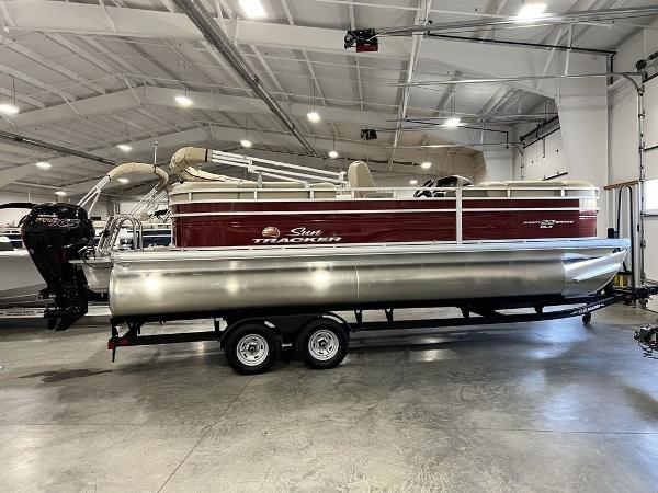 Sun Tracker PARTY BARGE® 22 RF DLX 2025 Sun Tracker PARTY BARGE® 22 RF DLX pontoon boat in a showroom.