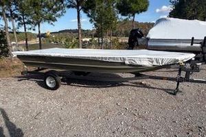 Tracker Grizzly 1648 Utility 2026 Tracker Grizzly 1648 Utility boat on trailer, covered, parked outdoors.
