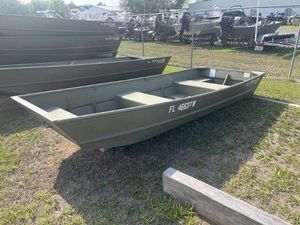 Lowe L1240 Jon 2024 Lowe 1240 boat on grass, parked near a fence in a sunny outdoor setting.