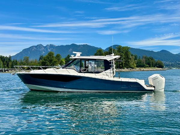 Boston Whaler 405 Conquest 2023 Boston Whaler 405 Conquest boat on a scenic lake with mountains in the background.