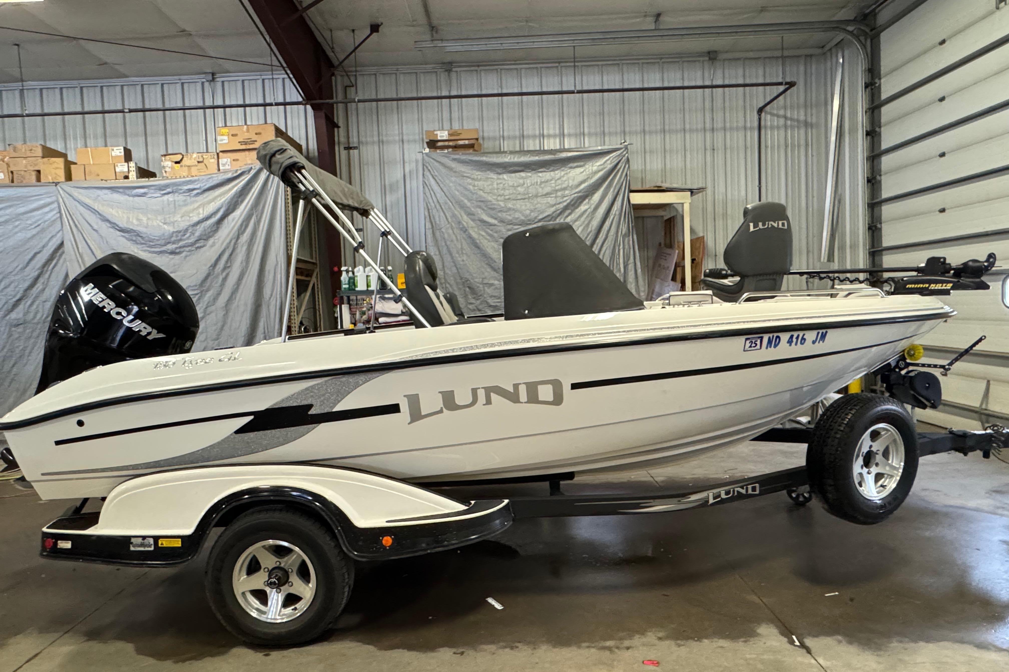 Lund 186 Tyee GL 2009 Lund 186 Tyee GL boat in a garage, on a trailer, with Mercury engine.