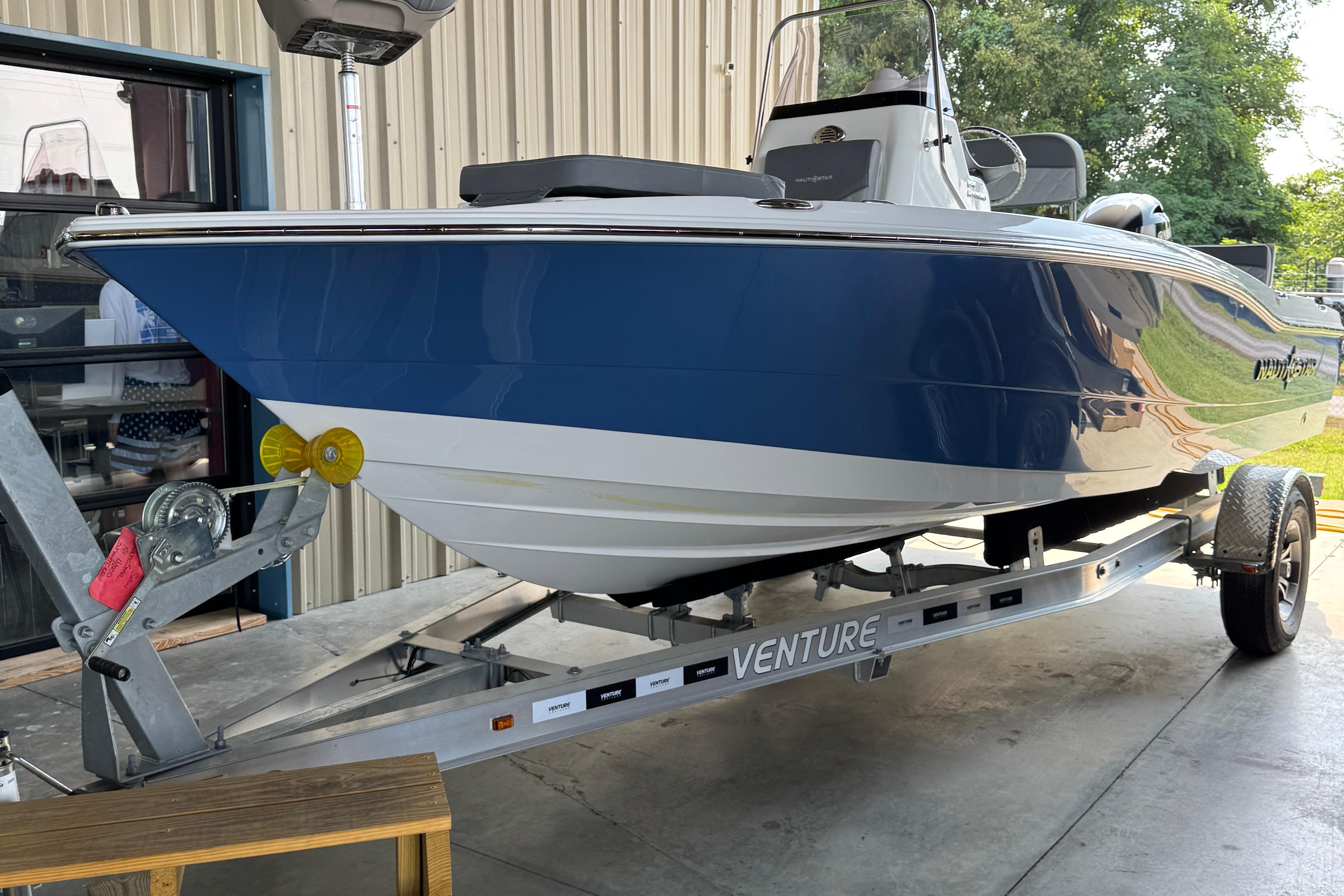 NauticStar 191 Hybrid 2024 NauticStar 191 Hybrid boat on trailer, blue and white hull, parked outdoors.