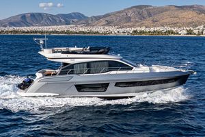 Azimut 53 2023 Azimut 53 yacht cruising on blue ocean with scenic mountain backdrop.