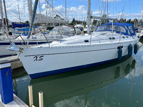 Beneteau Oceanis 351 1998 Beneteau Oceanis 351 sailboat docked in marina, featuring blue accents and protective canopy.
