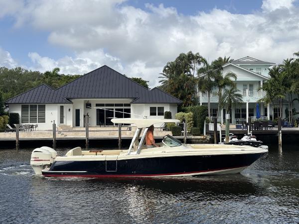 Chris-Craft Calypso 30 2019 Chris-Craft Calypso 30 boat cruising near waterfront homes.