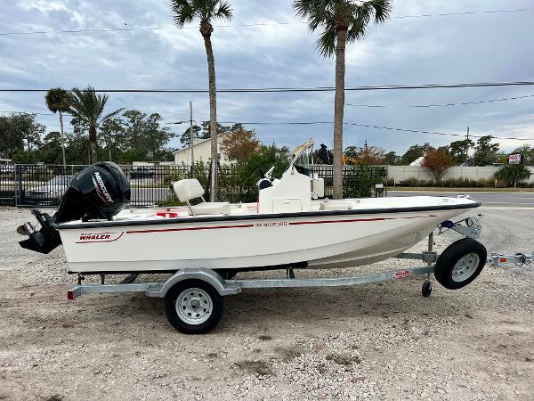 Boston Whaler 150 Montauk 2025 Boston Whaler 150 Montauk boat on trailer, parked outdoors with palm trees.