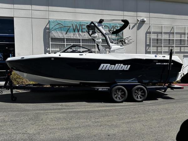 Malibu Wakesetter 25 LSV 2025 Malibu Wakesetter 25 LSV boat on trailer outside dealership.