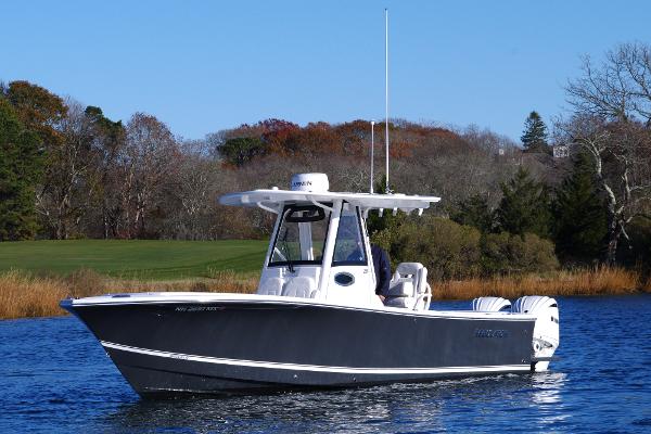 Regulator 28 2023 Regulator 28 boat on a calm lake with autumn trees in the background.