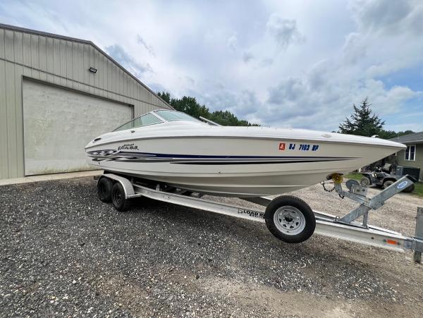 Wellcraft 260 Excalibur Sport 2001 Wellcraft 260 Excalibur Sport boat on a trailer outside a storage building.