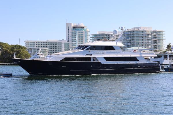 Broward 124 Tri-Deck MY 1988 Broward 124 Tri-Deck MY yacht cruising near modern waterfront buildings.