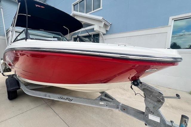 Sea Ray 19 SPX OB 2018 Sea Ray 19 SPX OB boat with red hull on trailer, parked outdoors.