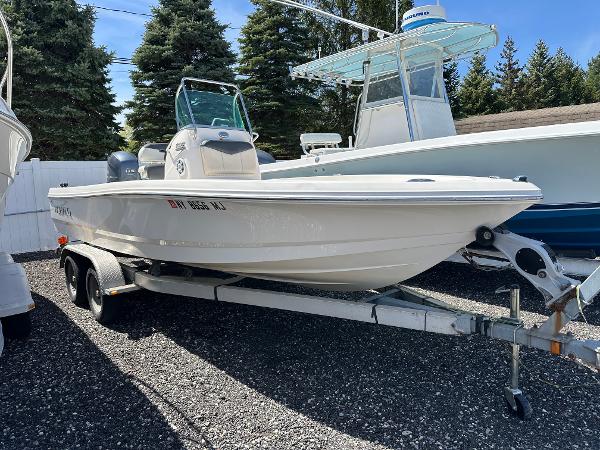 Robalo 206 Cayman 2014 Robalo 206 Cayman boat on trailer, parked outdoors with trees in background.