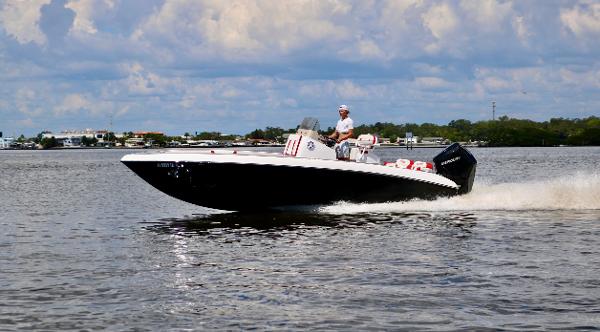 Statement 24 Speedboat cruising on water, Statement 24 model, 2025, under a partly cloudy sky.