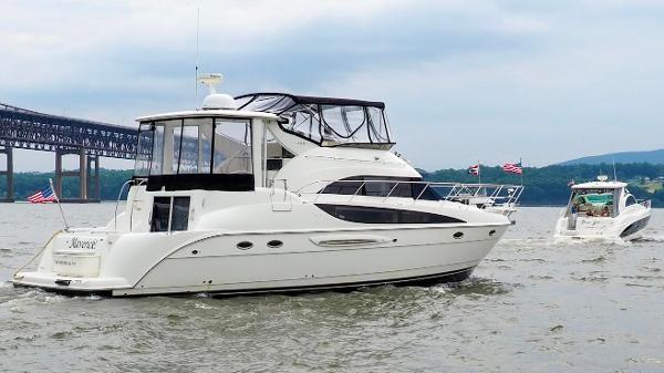 Meridian 459 Motoryacht 2005 Meridian 459 Motoryacht cruising on a river with bridge and boats in the background.
