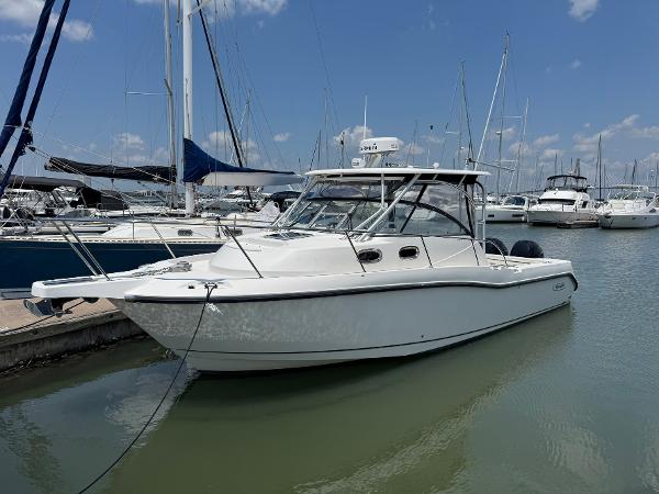 Boston Whaler 305 Conquest 2011 Boston Whaler 305 Conquest boat docked in a marina under a clear blue sky.