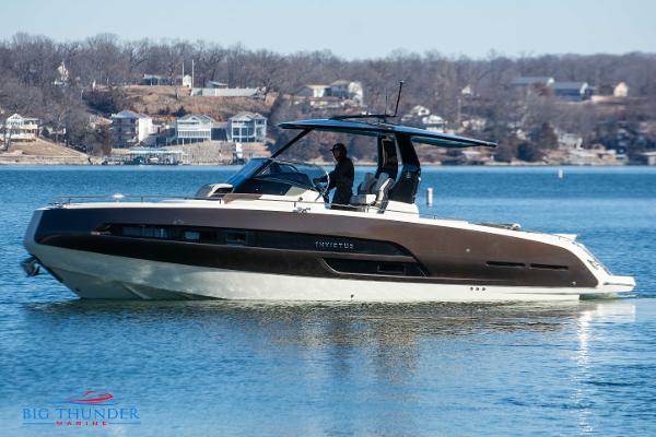 Invictus GT320 2024 Invictus GT320 luxury motorboat cruising on a lake near residential area.