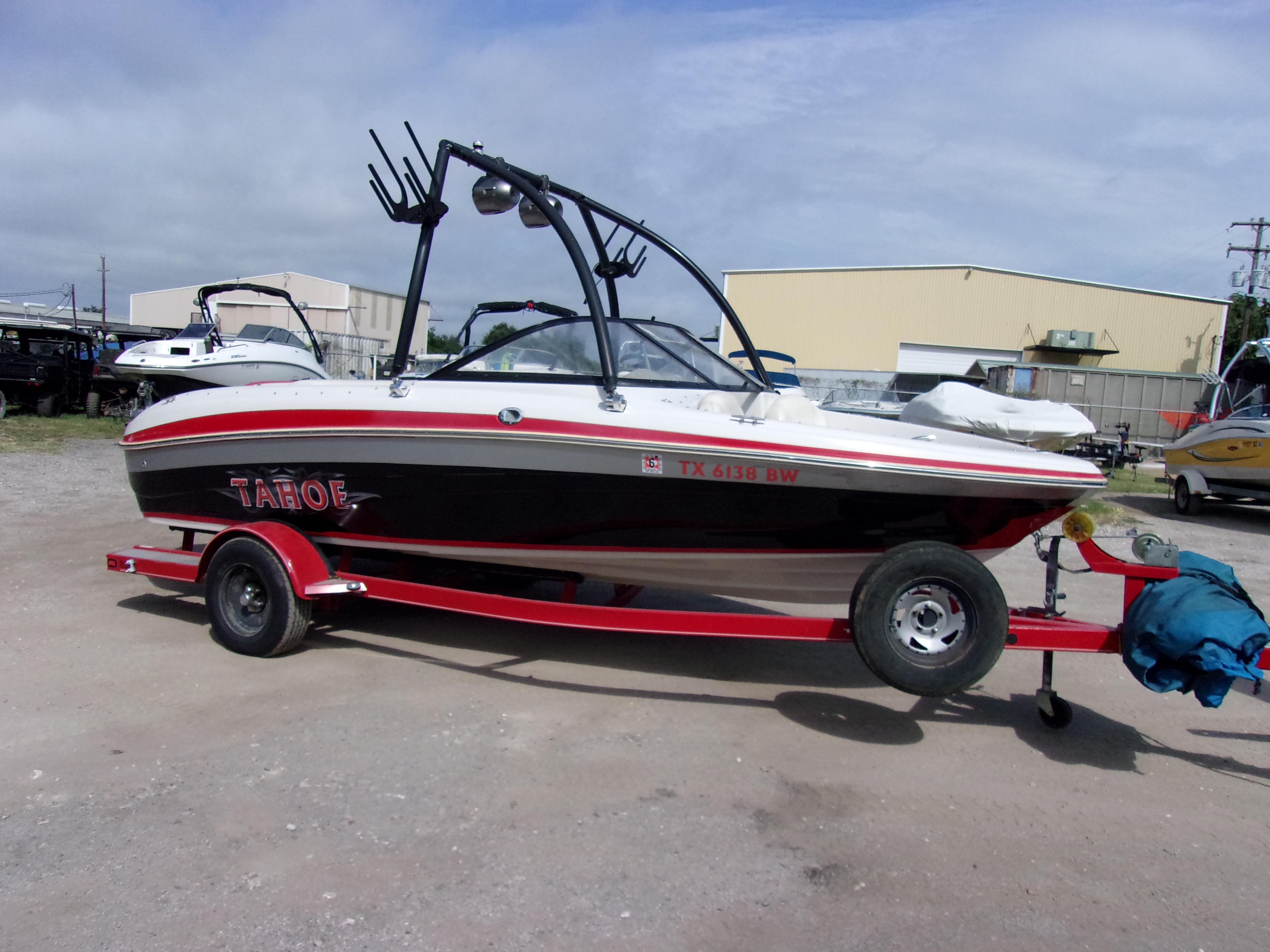 Tahoe Q5i 2011 Tahoe Q5i boat on trailer, parked outdoors, with red and black design.
