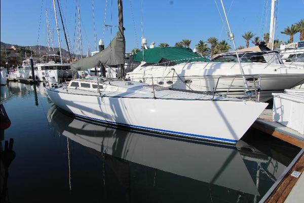 Olson 40 1982 Olson 40 sailboat docked in a marina, reflecting on calm water.