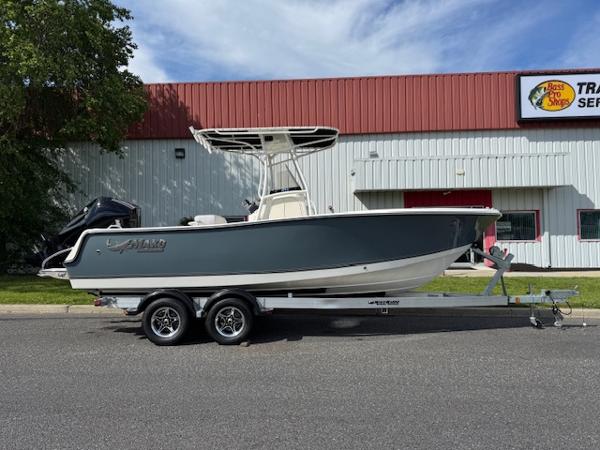 Mako 214 CC 2025 Mako 214 CC boat on trailer, parked outside a building.