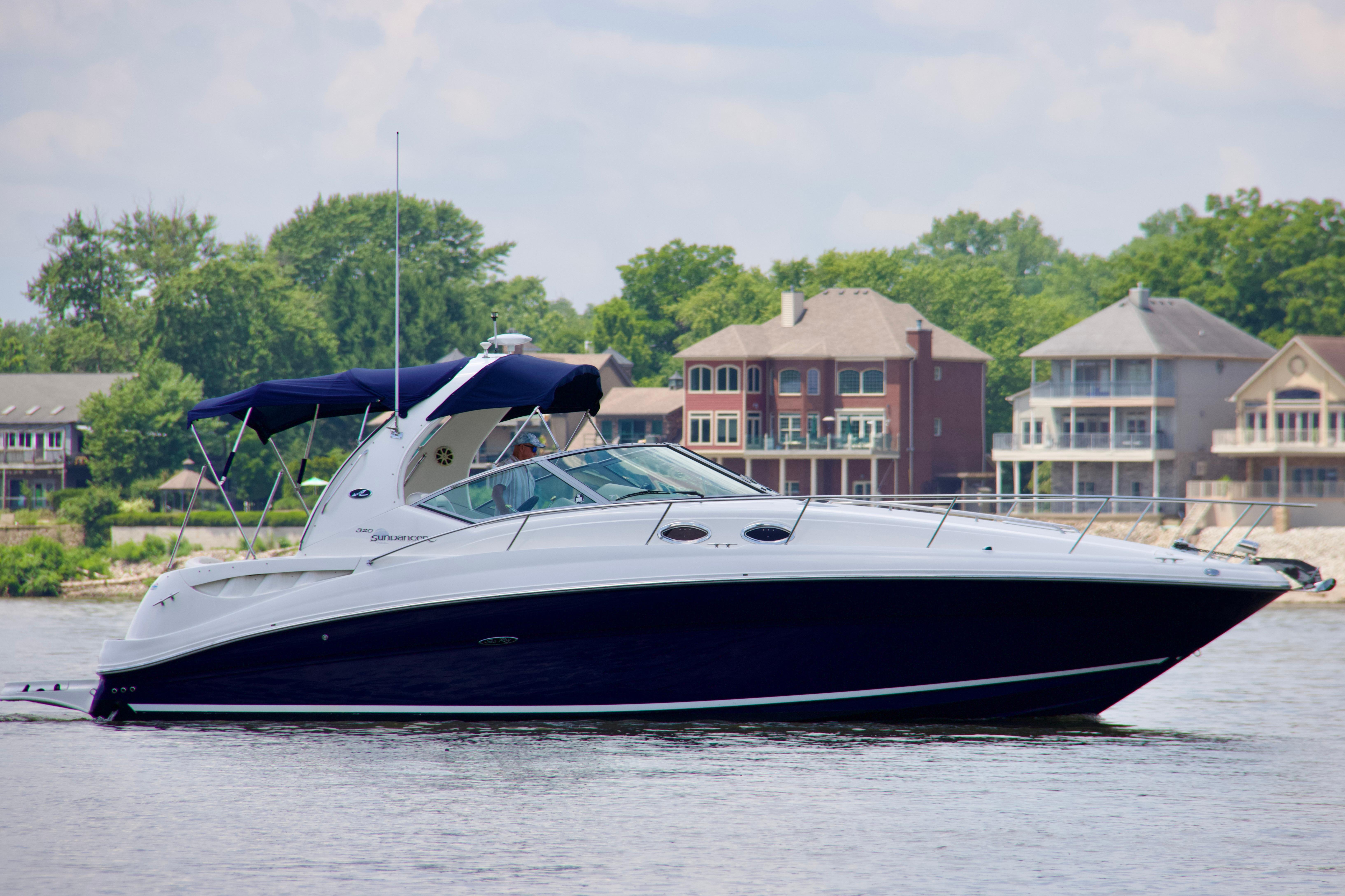 Sea Ray 320 Sundancer 2004 Sea Ray 320 Sundancer yacht cruising near waterfront homes.