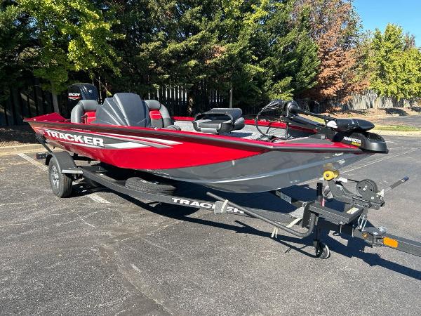 Tracker Pro Team 175 2025 Tracker Pro Team 175 boat, red and gray, on a trailer in a parking lot.