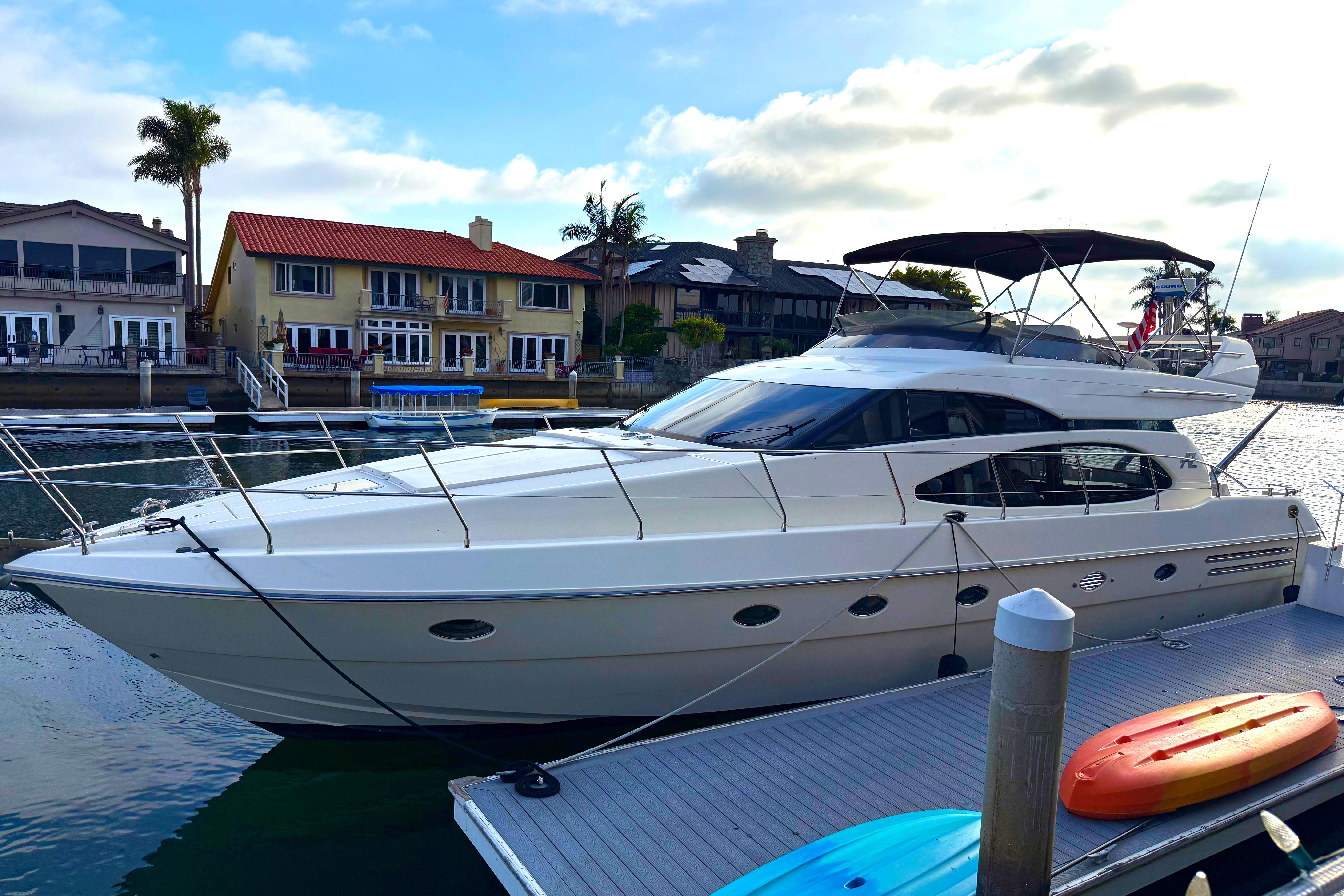 Azimut 54 Luxury 1996 Azimut 54 yacht docked near waterfront homes, with kayaks on the pier.