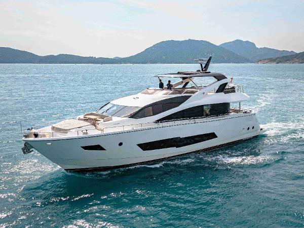Sunseeker 86 Yacht 2016 Sunseeker 86 Yacht cruising on blue waters with scenic mountain backdrop.