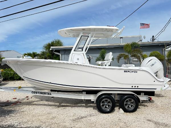 Sea Fox 228 Commander 2025 Sea Fox 228 Commander boat on trailer, parked outdoors with American flag in background.