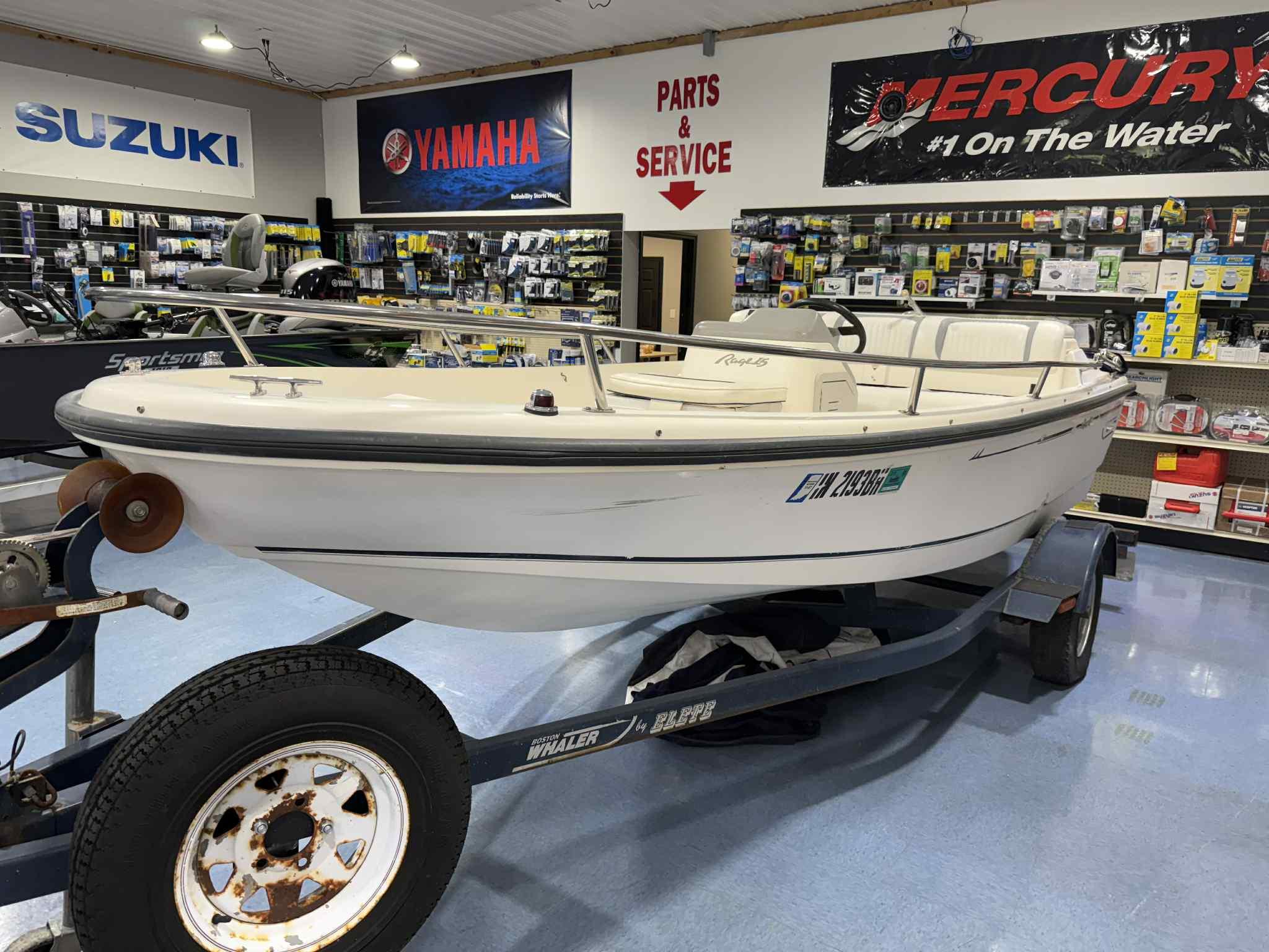 Boston Whaler Rage 15 1997 Boston Whaler Rage 15 boat displayed in a showroom with Yamaha and Suzuki signage.