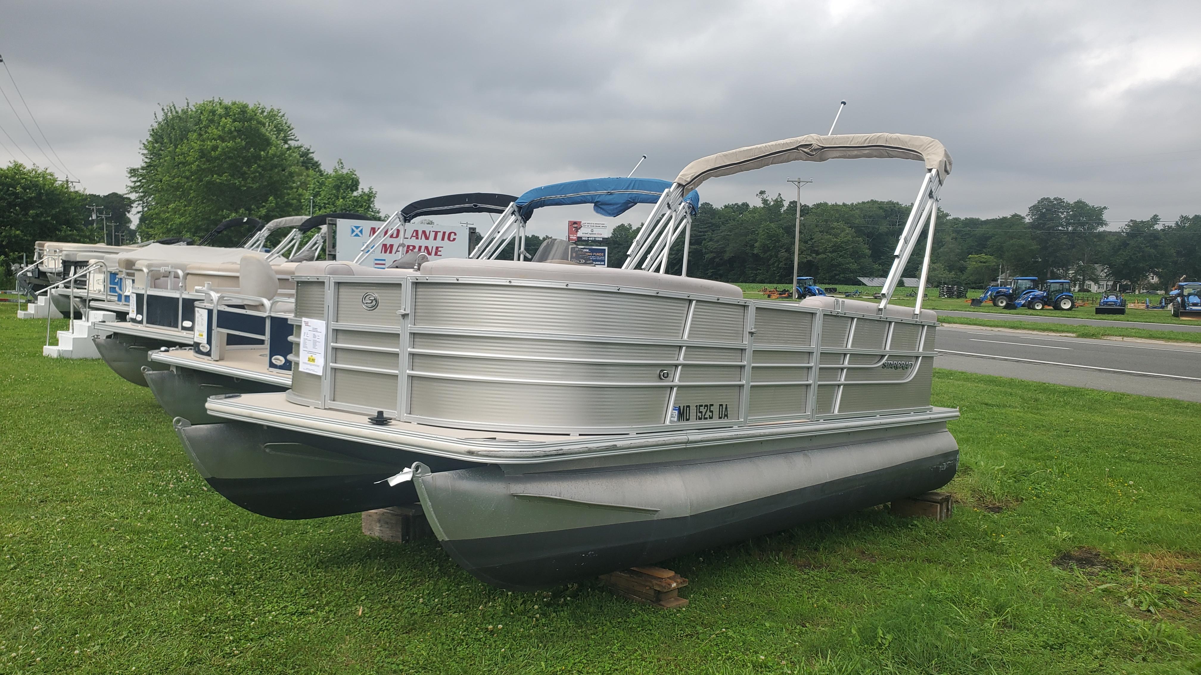 Starcraft SD 190 2014 Starcraft SD 190 pontoon boat displayed on grass, overcast sky background.