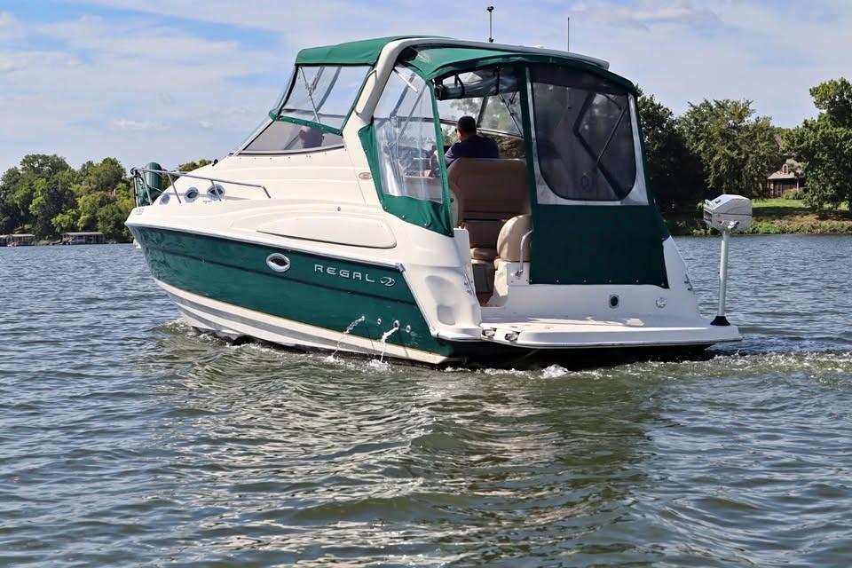 Regal Commodore 2860 2002 Regal Commodore 2860 boat cruising on a lake with green canopy.
